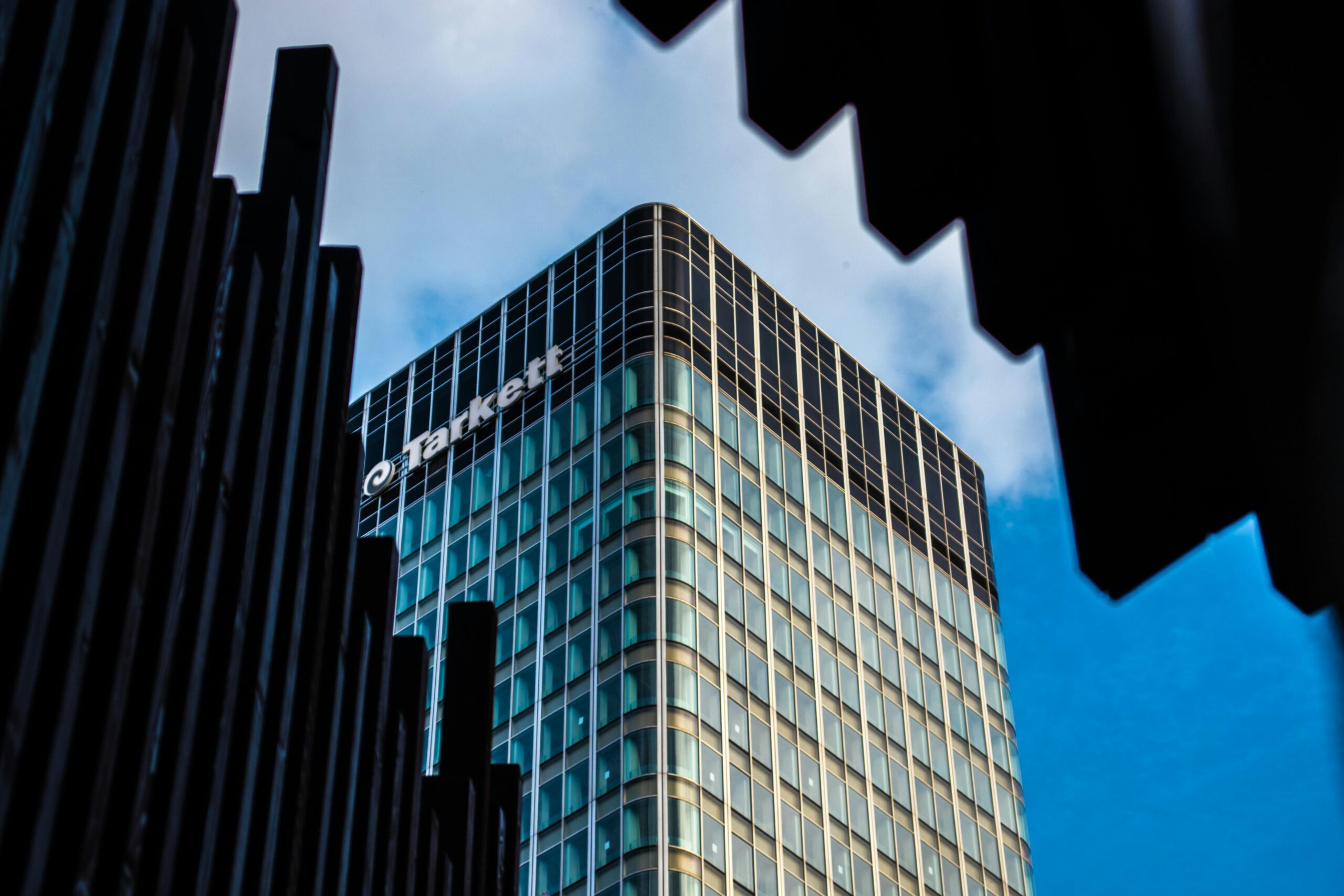 Contemporary glass office building in Paris with a futuristic design against a clear blue sky.